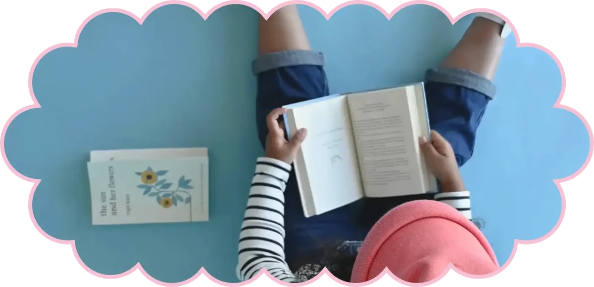 Child reading a book on a blue surface with educational materials